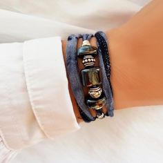 Elegant Boho Chic bracelet in worn navy blue and silver. This bohemian and hippie style bracelet is at the same time very elegant and youthful. It is made up of a ribbon in a gradient blue tone and decorated with various Greek porcelain and steel charms. It is very easy to put on by wrapping it around your wrist three times and then tying it at the back. It is ideal to give a boho chic touch to your outfit. In addition, you can also use it as a necklace or choker, the result is ideal and very fl Elegant Adjustable Wrap Bracelet For Festival, Elegant Hand Wrapped Festival Wrap Bracelet, Elegant Festival Wrap Bracelet, Bohemian Adjustable Wrap Bracelet For Party, Elegant Blue Wrap Bracelet As A Gift, Elegant Blue Wrap Bracelet As Gift, Elegant Handmade Blue Friendship Bracelets, Elegant Handmade Blue Wrap Bracelet, Blue Silk Ribbon