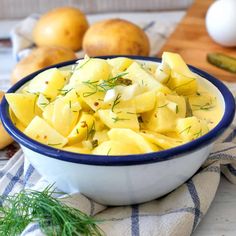 a blue and white bowl filled with potato salad