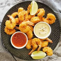 a plate with shrimp and dipping sauces on it