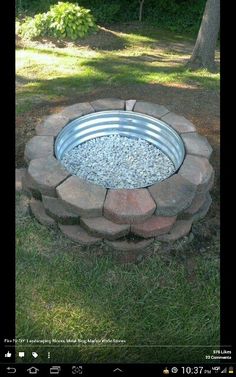 a fire pit made out of bricks in the grass