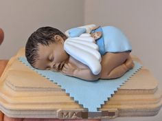 a small figurine of a man laying on top of a wooden box with a blue blanket