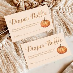 two orange pumpkins are on top of some rafter raffle tags with the words diaper raffle