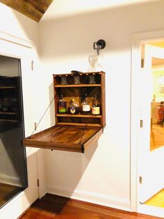 an open shelf in the corner of a room with wooden flooring and white walls