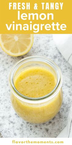 a mason jar filled with fresh and tangy lemon vinaigrette on top of a marble counter