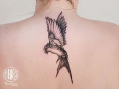 the back of a woman's neck with a bird tattoo on it