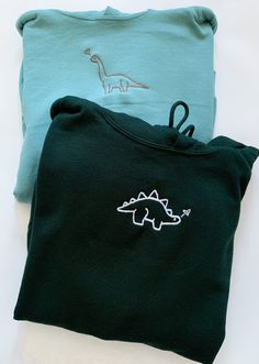 ✰COMES WITH TWO! ITEM 1: refers to long neck dinosaur ITEM 2: refers to the spiky dinosaur Example shown: Sage Green Hoodie X Brown Thread // Forest Green Hoodie X White Thread ✰Embroidered Matching Sets. Sage Green sweatshirt is a lighter shade compared to the hoodie✰UNISEX✰Hand drawn and designed✰Super soft and comfy! *Sizes 2XL-3XL may be subject to longer processing times since we don't carry a large amount of inventory in those sizes, so we would have to put in a special order from our supp Sage Green Sweatshirt, Sage Green Hoodie, Forest Green Hoodie, Long Neck Dinosaur, Matching Hoodies For Couples, Matching Hoodies, Embroidery Hoodie, Forest Green Color, Matching Sweatshirts