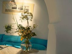 a vase filled with flowers sitting on top of a table next to a blue couch