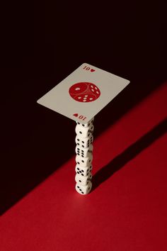 a white dice sitting on top of a red table