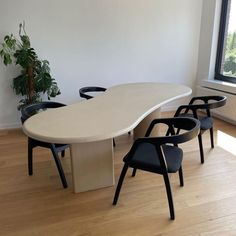 an oval table with four chairs around it