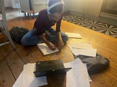 a person sitting on the floor with some papers and a keyboard in front of them