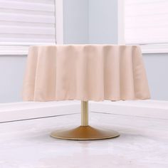 a round table with a beige cloth on it