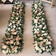 two rows of white and pink flowers are lined up on the floor next to each other