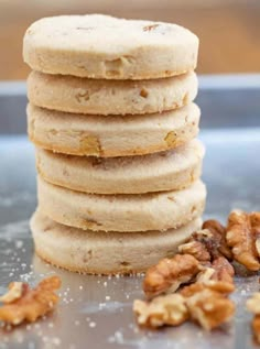 a stack of cookies with walnuts next to it