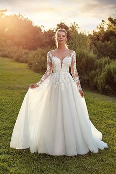 a woman in a wedding dress standing on the grass