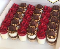 there are many desserts in the box with chocolate and strawberries on top,