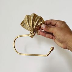 a hand holding a gold colored metal object