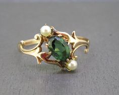 Gorgeous antique ring featuring a green tourmaline and tiny pearls.  Has a 10k gold setting, unmarked but tested and guaranteed 10k gold by me.  Light wear, no major issues. Size 6 3/4 Weighs approx. .8g Visit Ribbons Edge for more great pieces of vintage and antique jewelry!  All items added to your cart at Ribbons Edge will automatically combine shipping. To stay up to date with my newest offerings, follow me on IG @ RibbonsEdge Signet Engagement Rings Women, Historical Jewellery Ancient Jewelry, Vintage Rings Antiques, Funky Engagement Rings, Tourmaline Engagement Rings, Signet Engagement Rings, Ring With Pearls, Antique Emerald Ring, Funky Jewellery