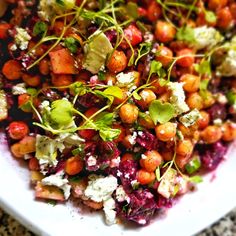 a white bowl filled with lots of food on top of a table next to a fork