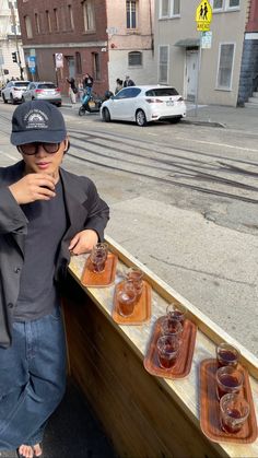 a man standing next to a wooden table filled with glasses on it's side