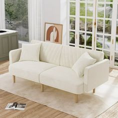 a white couch sitting on top of a hard wood floor