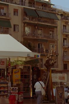 a man walking past a tall building with balconies on the top and below it