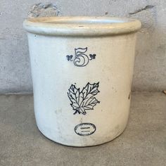 a white pot with black designs on the side and numbers 5 in front of it