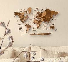 a living room with a white couch and a wooden world map on the wall above it