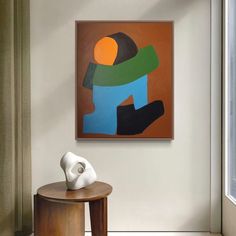 an abstract painting hangs on the wall next to a small table with a white sculpture