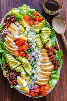 a large salad with avocado, tomatoes, lettuce and other vegetables