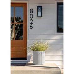 a white planter sitting in front of a door