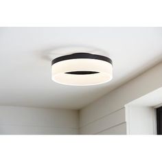 a white ceiling light hanging from the ceiling in a room with black and white trim