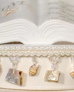 an open book sitting on top of a table next to some charms and bookshelves