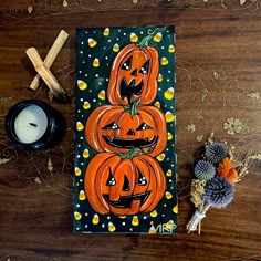 two pumpkins are sitting on a table next to a candle and some other decorations