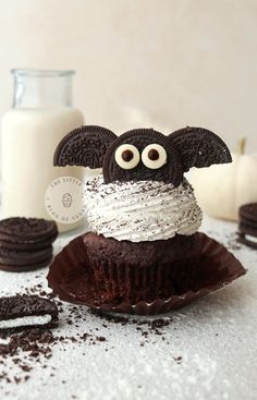 a chocolate cupcake with white frosting and googly eyes