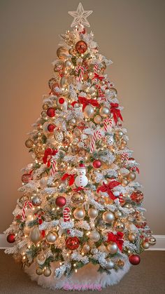 a white christmas tree with red and gold ornaments