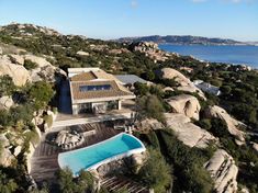 an aerial view of a house with a pool in the foreground and mountains in the background