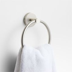 a towel hanging on the wall next to a toilet paper roll and a metal ring