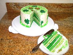 there is a cake with green frosting on the plate and one has a slice missing