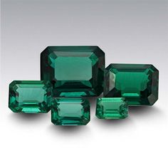 three emerald colored stones sitting next to each other