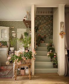 there are many potted plants on the stairs in this room and one is sitting