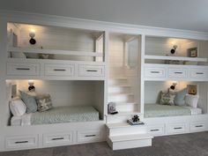 two white bunk beds sitting next to each other on top of a carpeted floor