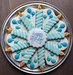 a birthday cake decorated with blue icing and frosting on top of a wooden table