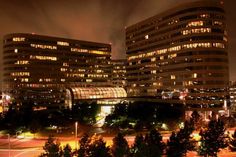 two large buildings are lit up at night