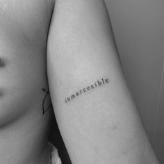 a woman's arm with the word impossible written on it and an arrow tattoo