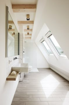 a bathroom with white walls and tile flooring next to a skylighted window