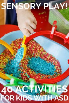 a child playing with sprinkles in a red bowl on top of a table