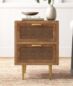 a wooden side table with two drawers and a potted plant sitting on top of it