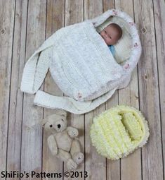 there is a baby in a crocheted bag next to a teddy bear