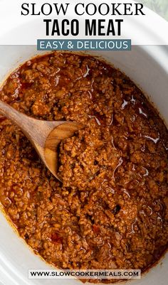 slow cooker taco meat in a white bowl with a wooden spoon on top