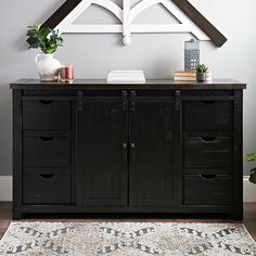 a black cabinet with drawers underneath a clock